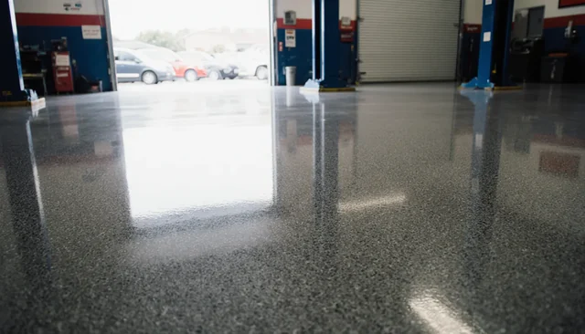 Epoxy flake floor in an auto service shop, high gloss, reflecting an open bay door